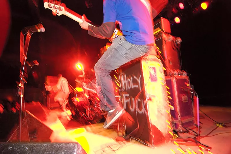 Image: Jonny DeStefano jumping with his bass with the Hate Fuck Trio.