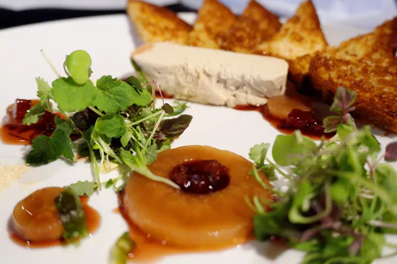 Image: An artistic plating of mousse, pear, brioche and herbs at Charcoal Bistro.