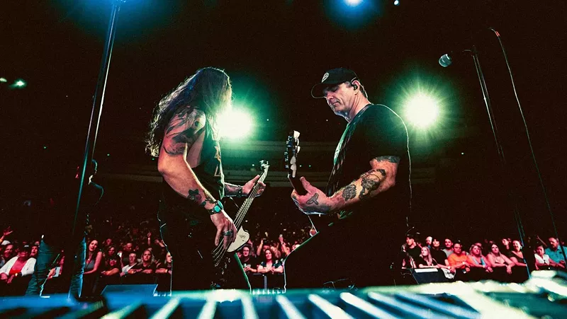 Image: two men playing bass and guitar on stage