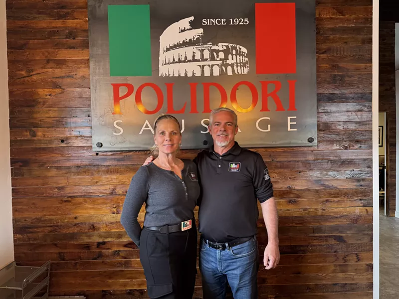 Image: woman and man in front of a "polidori" sign