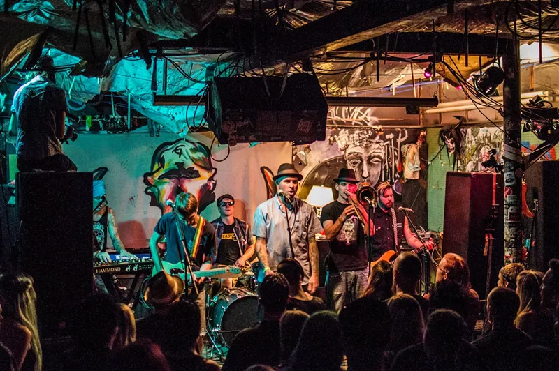 Image: A band plays on stage to a crowded room