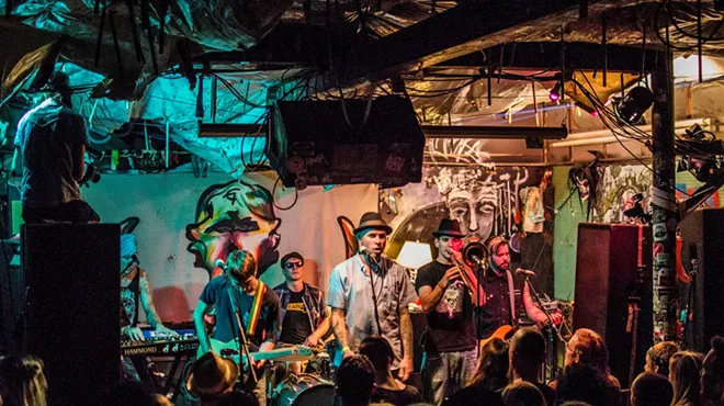 A band plays on stage to a crowded room
