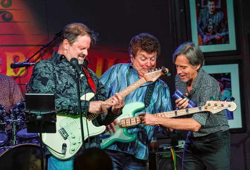 Image: three men playing guitar