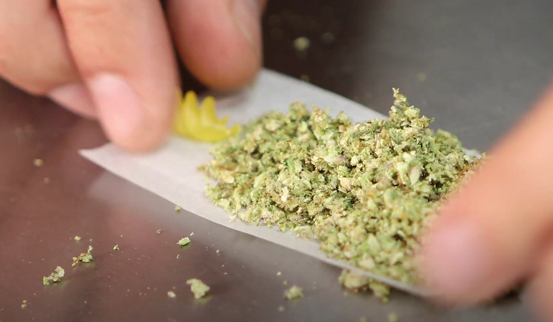 Image: perosn rolls joint with noodle crutch
