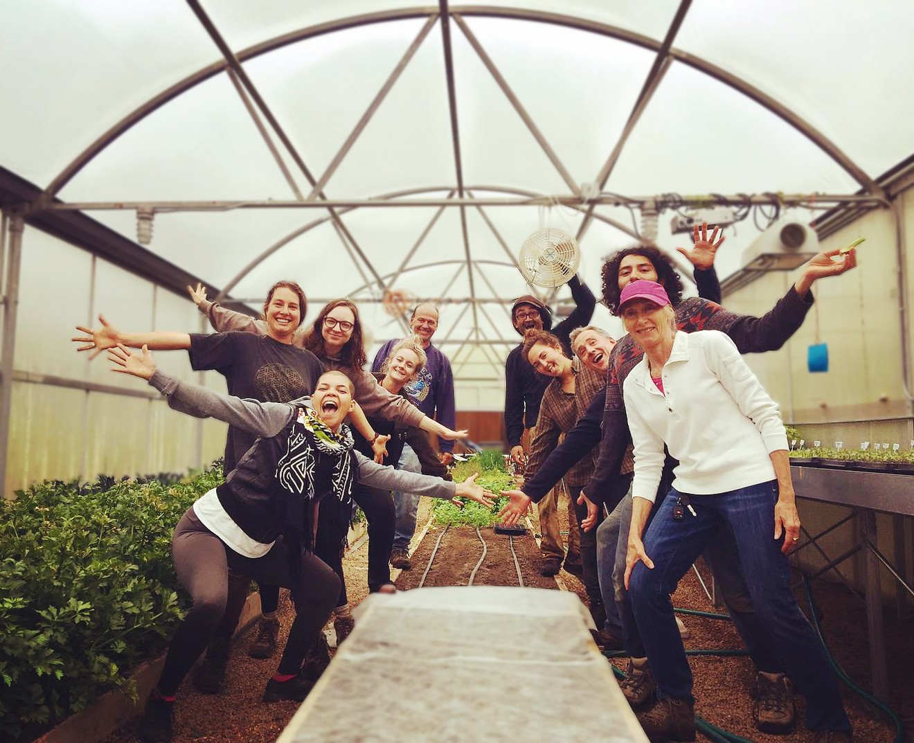 Sunrise Ranch members pose for a picture inside the property's greenhouse.
