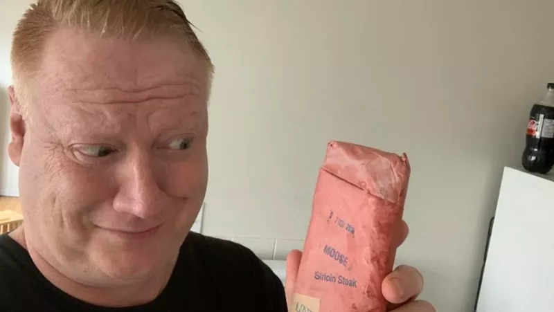 Image: Adrian Dater eyeballing a slab of moose meat he found in the freezer of his Edmonton Airbnb.