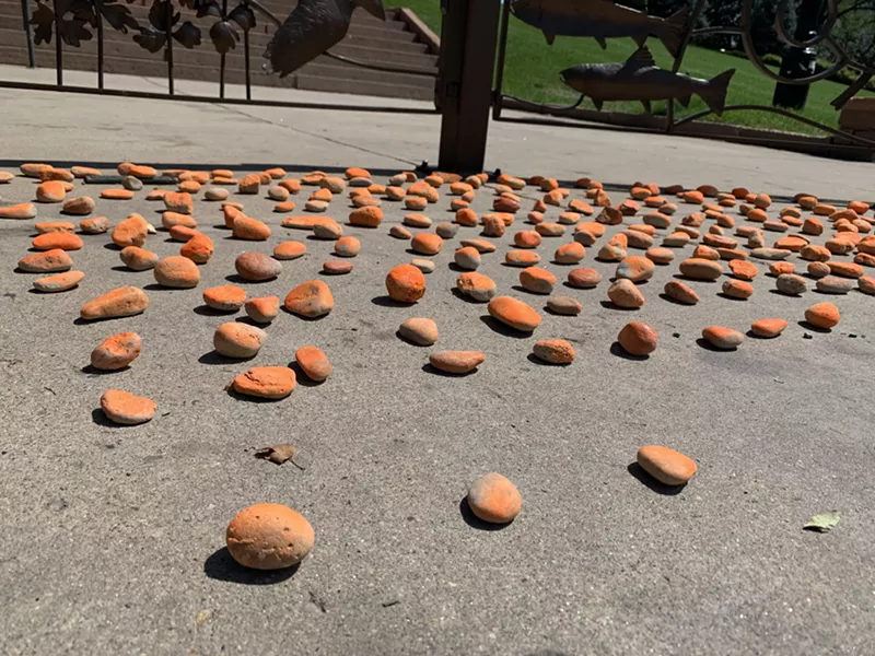 Image: Advocates laid out close to 900 orange stones to represent those who contracted COVID-19 in Colorado prisons. Three have died.