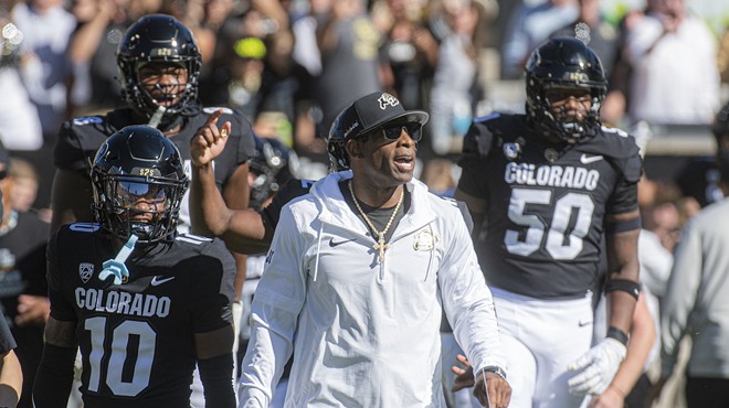 CU football coach Deion Sanders surrounded by Buffalo football players.