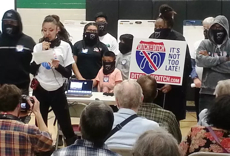 Image: Community activist Candi CdeBaca (with microphone) and other protesters blasted the highway project before CDOT officials spoke at Thursday night's meeting at the Swansea Recreation Center.