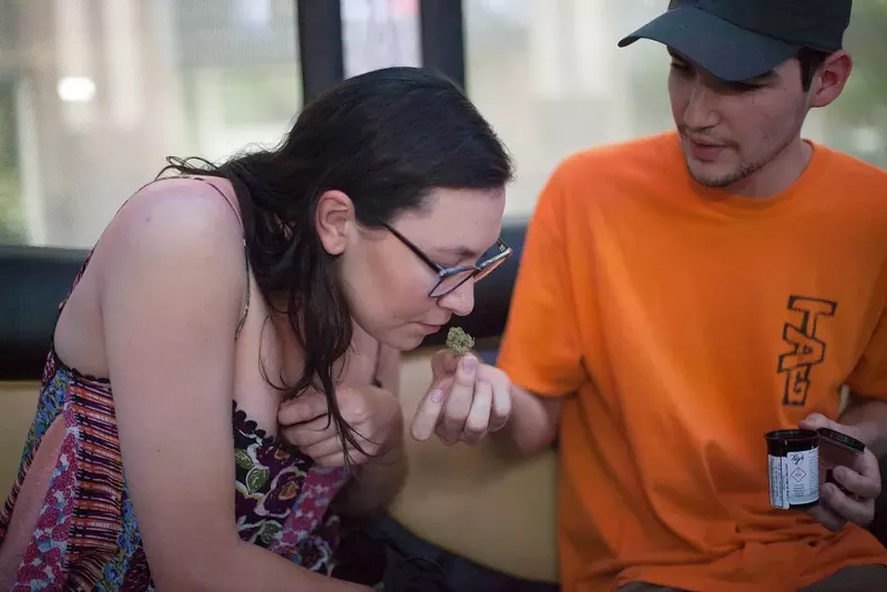 Image: Riders of the Loopr mobile marijuana lounge check out a dispensary purchase.