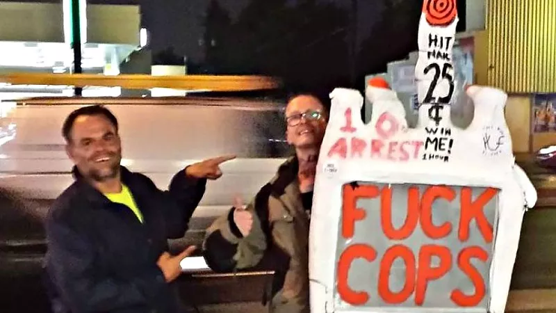 Image: Eric Brandt, left, gets an assist with his notorious "Fuck Cops" sign.