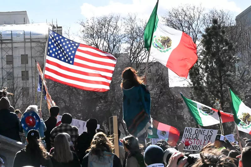 Image: A woman raises a flag.