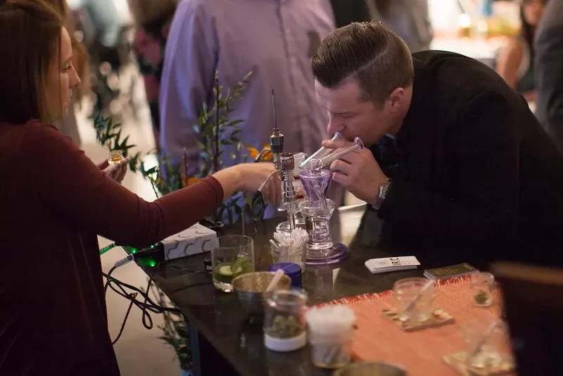 Image: A man takes a dab during a private party held by Mason Jar Event Group.
