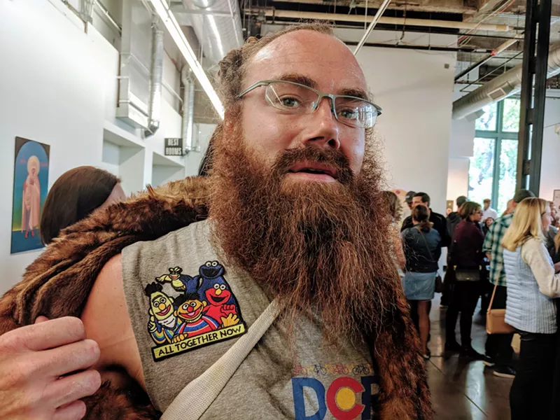 Image: Artist Kenneth Wheeler in a fur coat and patches from Denver Pop Culture Con.