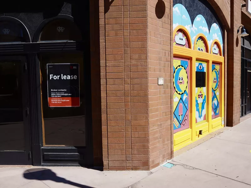 Image: an empty storefront with colorful art