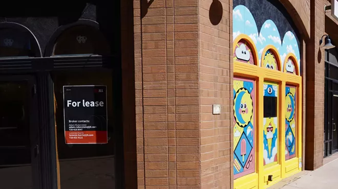 an empty storefront with colorful art