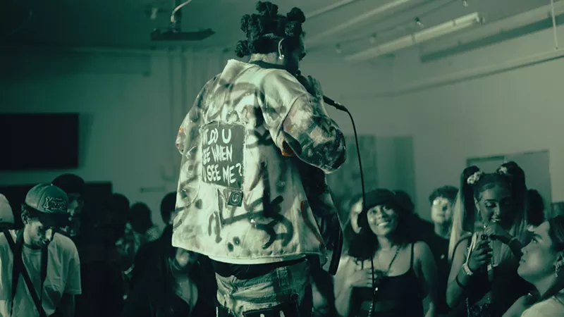 Image: back of a man holding a microphone