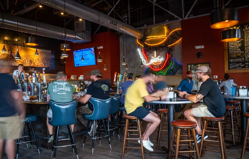 Image: people sitting at tables inside a bar