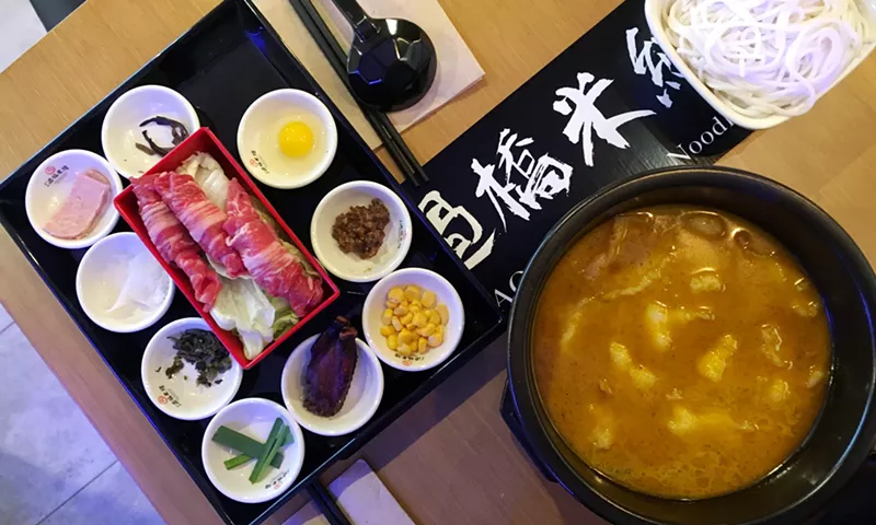 Image: The pickled-pepper broth with fish and ten different stir-in ingredients.