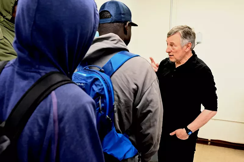 Image: A man talks to people.