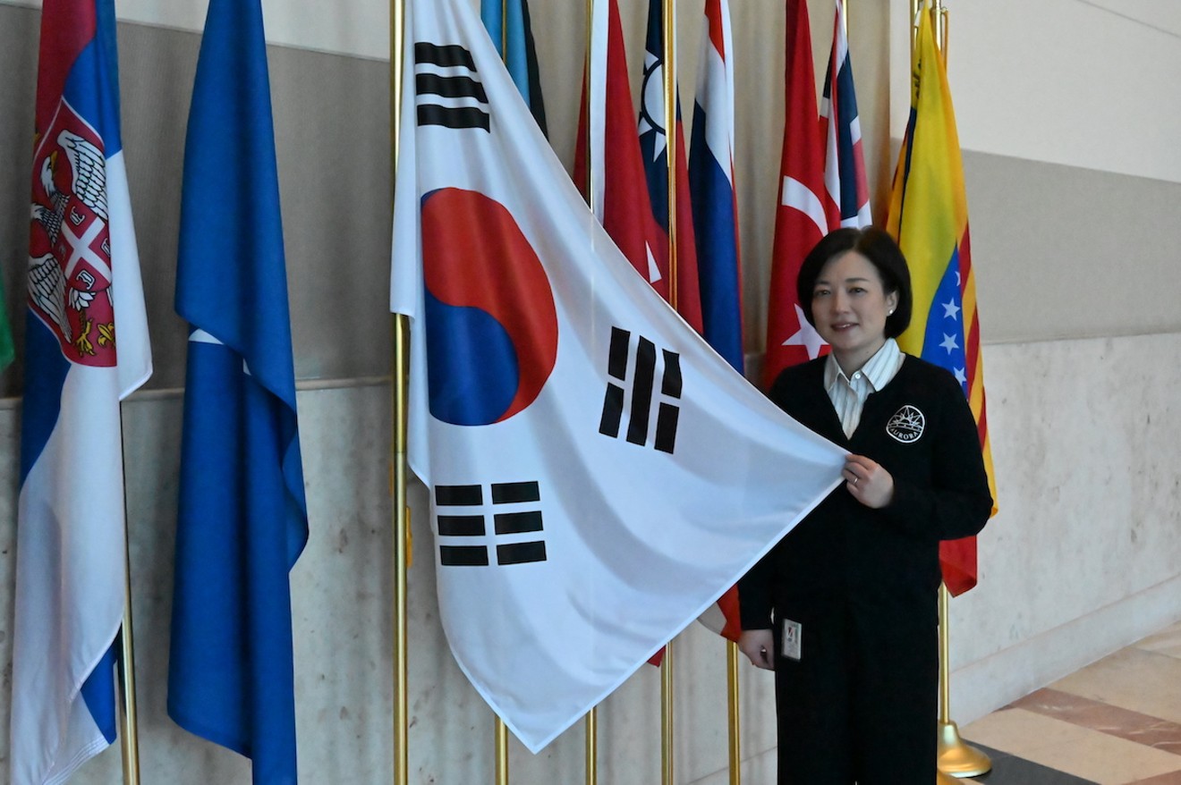 Minsoo Song, who's leading the effort for a South Korean consulate in Aurora, holds out a South Korean flag at the Aurora Municipal Center.