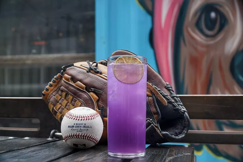 Image: a purple cocktail in front of a baseball glove