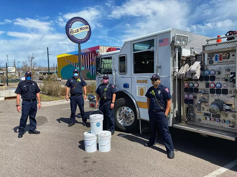 Image: The Denver Fire Department picks up buckets of hand sanitizer at Blue Moon Brewing.