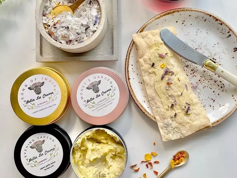 Image: a cracker spread with butter next to butter in packaging