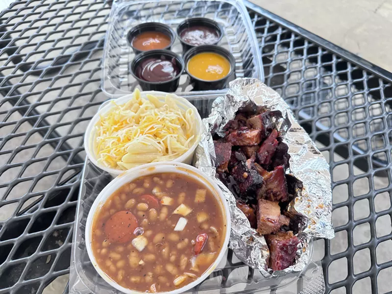 Image: Burnt ends, baked beans, and mac and cheese with a variety of barbecue sauces.