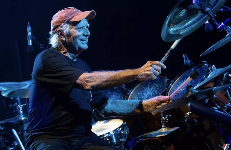 Image: man playing drums in red hat