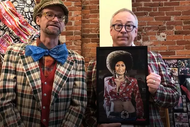 Image: Voodoo Doughnut founders Tres Shannon (left) and Kenneth Pogson with a reproduction of the Pam Grier painting that was stolen from the Denver doughnut shop.