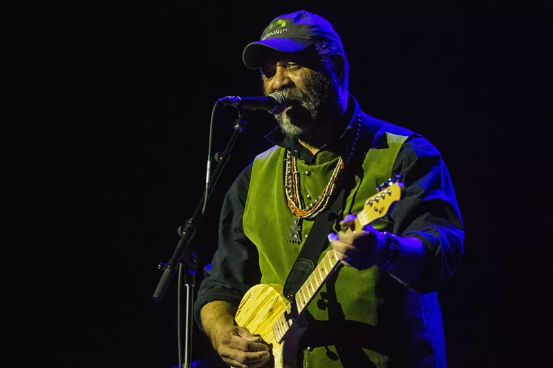 Image: man singing and playing guitar
