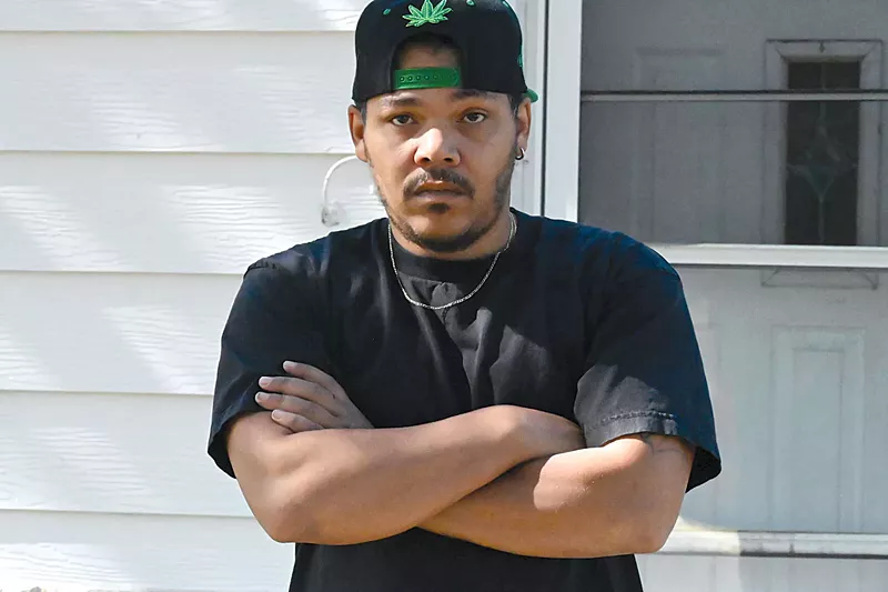 Image: rapper in black hat and shirt