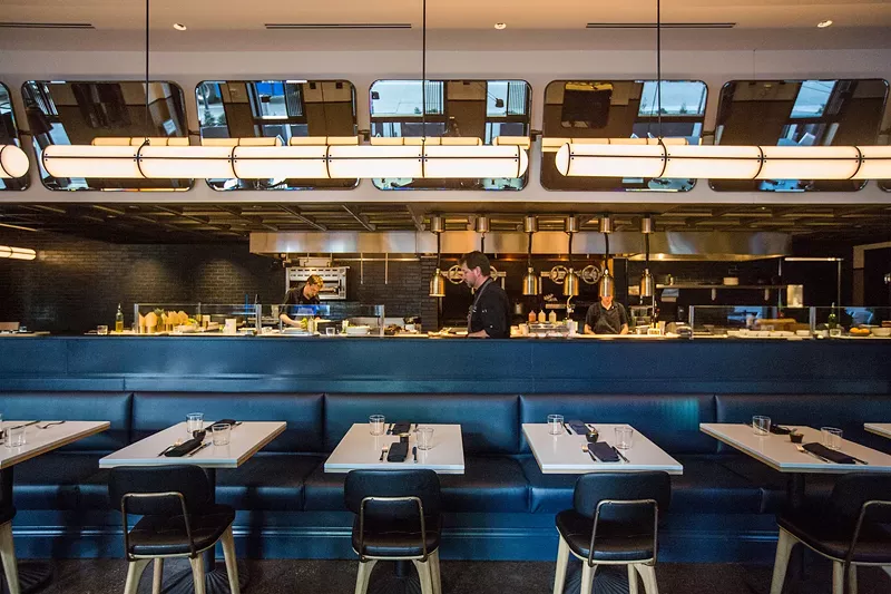 Image: tables in front of a restaurant kitchen