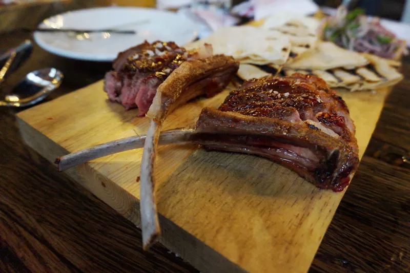 Image: Lamb "lollipops" served with housemade flatbread, mint crème fraîche and shaved onions with parsley.