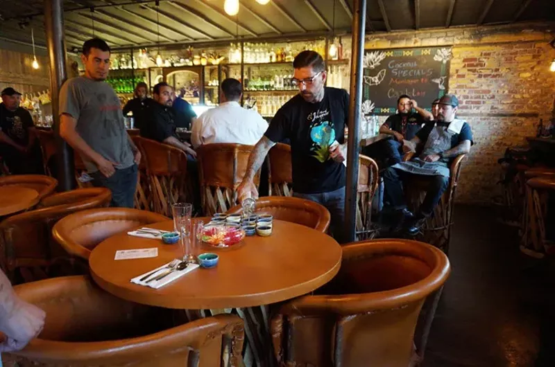 Image: Owner Brian Rossi sets the table at Palenque Mezcaleria.
