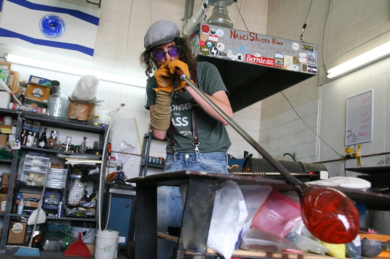 Bryan Goldfeder blowing glass to make a honey pot at his studio.