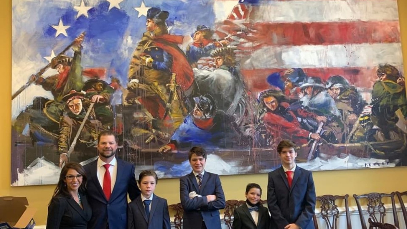 Representative Lauren Boebert and her family pose before a painting that honors the Revolutionary War to celebrate her congressional swearing in.