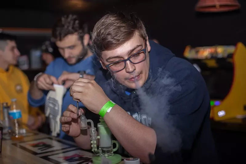 Image: Man blows out hit of cannabis smoke