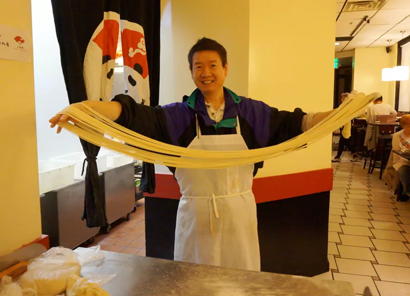 Image: Little Chengdu's owner pulls noodles in the middle of the restaurant.