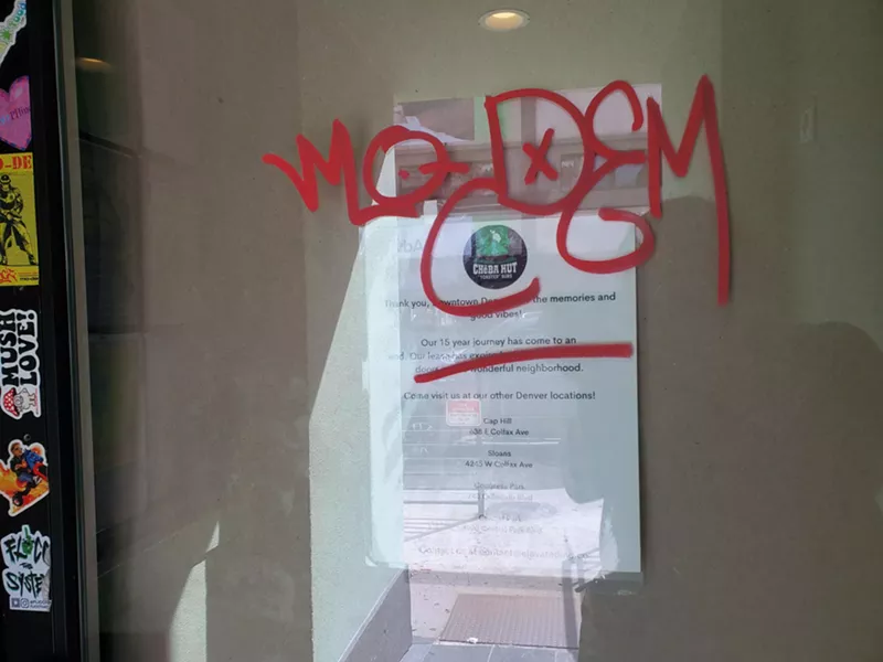 Image: a note on a glass door covered in red graffiti