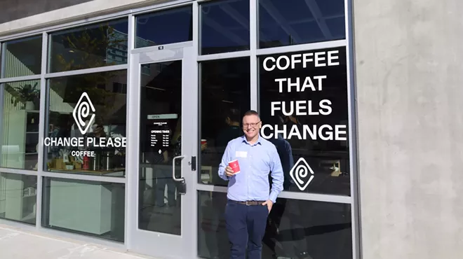 man standing in front of a window that says "coffee that fuels change"