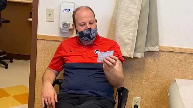 Image: Governor Jared Polis awaiting his first COVID-19 injection on January 30 — and wearing his mask a bit lower on his nose than is strictly advisable.