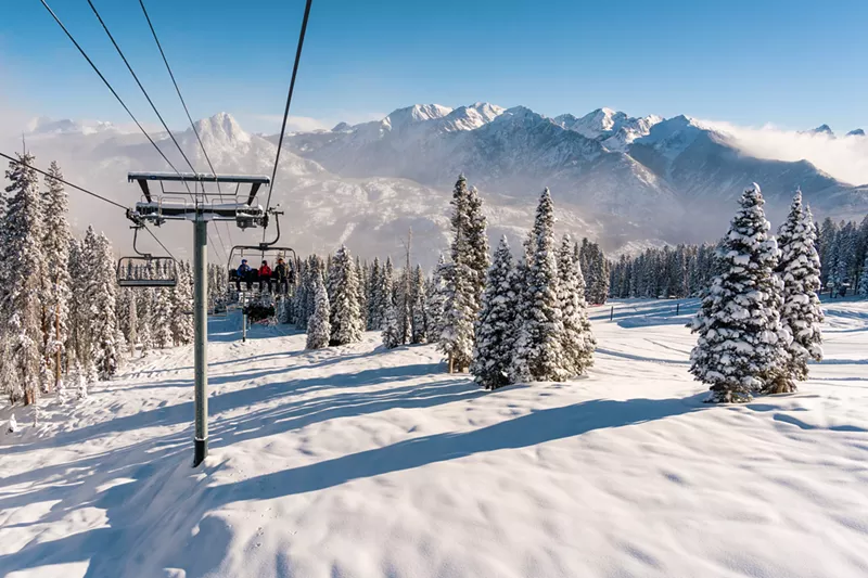 Image: A chairlift at Purgatory Resort backdropped by snowy peaks