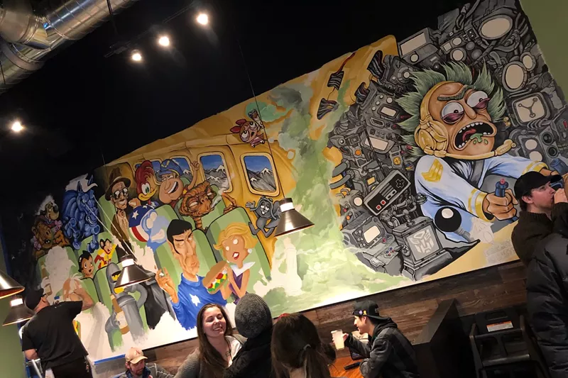 Image: Artist Joshua Finley puts the finishing touches on his new mural for Cheba Hut during friends-and-family night.