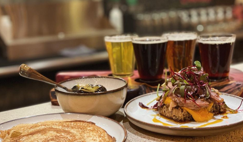 Image: various food on plates i front of three pints of beeer