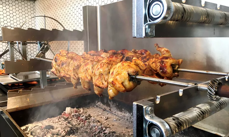 Image: Whole chickens roast on the Australian rotisserie grill at Chook.