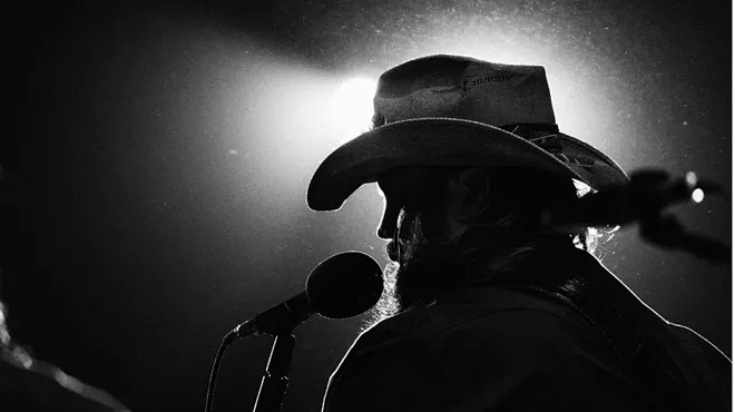 chris stapleton singing at a mic