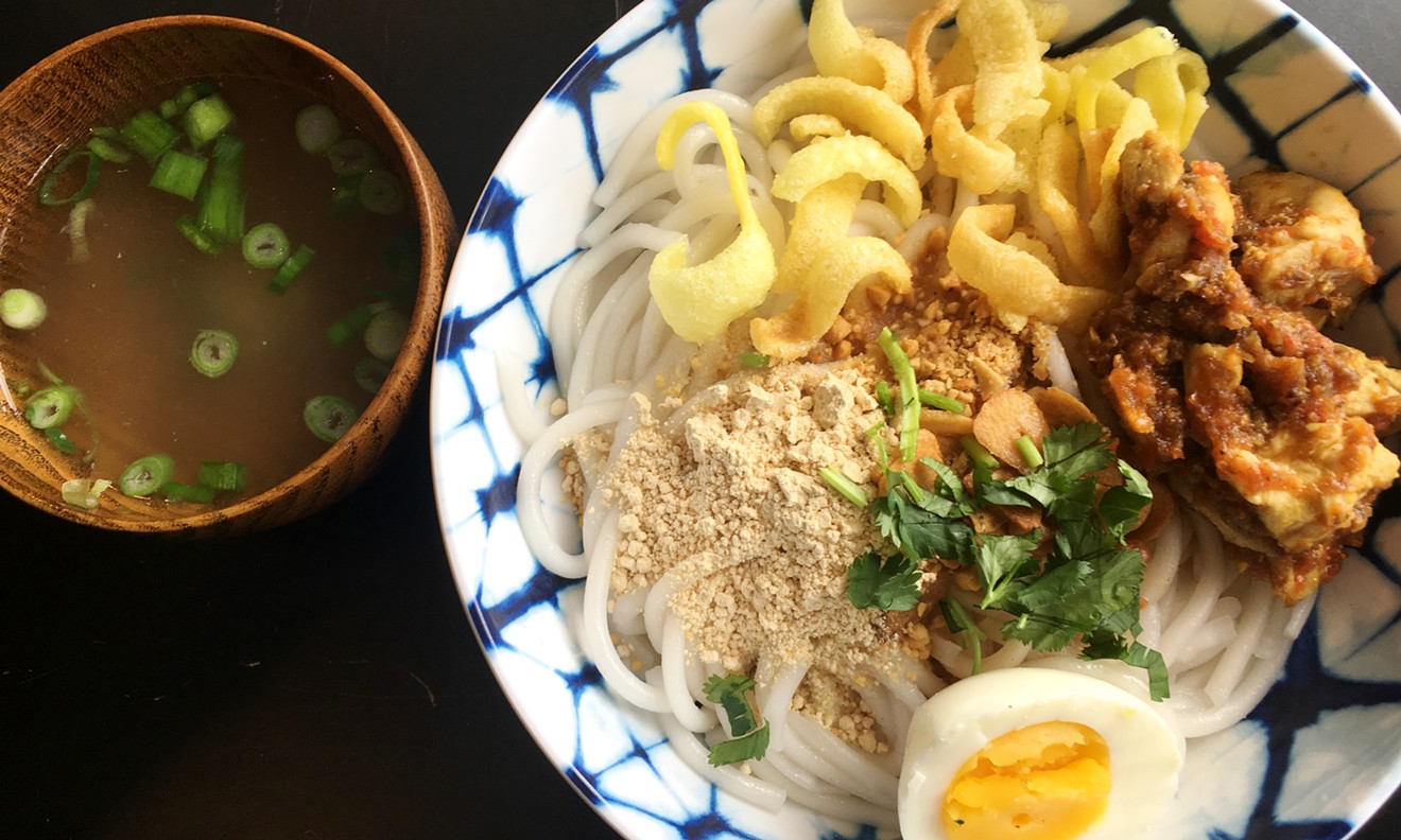 Nan gyi dok is made with thick rice noodles and chicken curry and served with a side of broth.