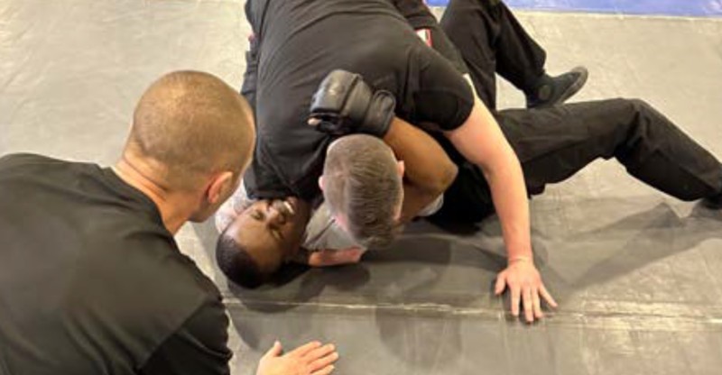 Police recruit Victor Moses seen struggling beneath Denver Police Officer Brian Camozzi during the January 2023 edition of "Fight Day."